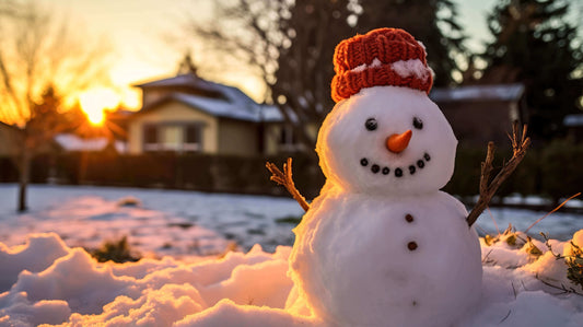 snowman with a setting sun going down behind a house in the background 